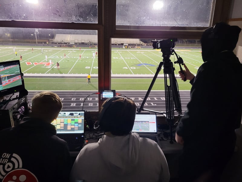 students working in the press box