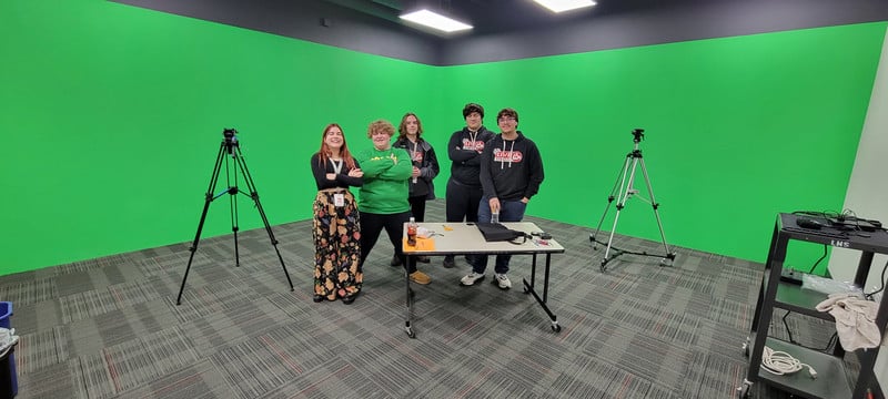students working in front of a green screen